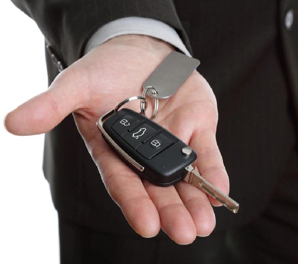 A man holding two keys to his car.